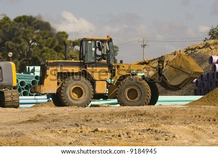 A front-end loader working hard with a bucket full of dirt