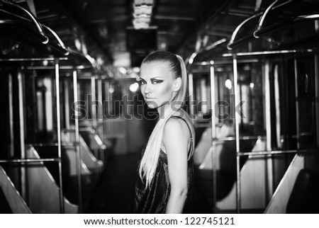A young girl in an underground subway. Train. Wagon. A woman. Station.