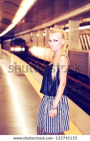 A young girl in an underground subway. Train. Wagon. A woman. Station.