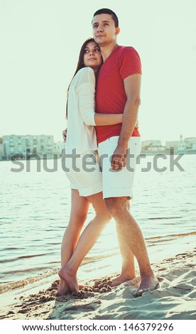 A love story. A man and a woman beautiful couple near the water on the shore of the sea and rivers. Love and kisses.