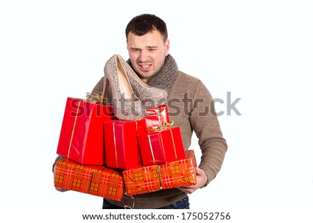 Emotional man holding a lot of gifts in his hands. Man bought a lot of gifts for the woman he loved. Women\'s shoes as a gift in the hands of men. Gifts in red packing for a holiday falls from hands.