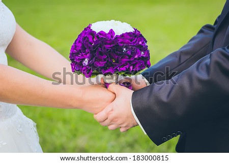 Wedding couple holding hands. Wedding decor. Bride and Groom wedding day. Beautiful wedding bouquet in hands of the bride and groom.