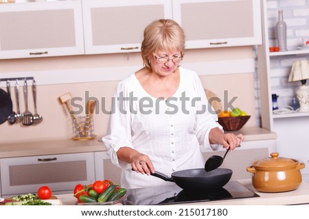 Beautiful adult multiracial woman while making lunch. Adult woman working in the kitchen. Mom while she work something else. Mother prepares. Cooking concept. Woman while preparing food in kitchen.