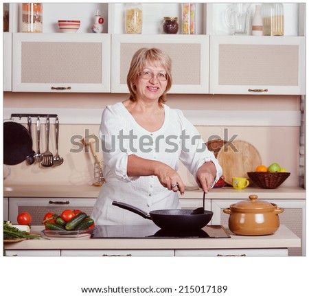 Beautiful adult multiracial woman while making lunch. Adult woman working in the kitchen. Mom while she work something else. Mother prepares. Cooking concept. Woman while preparing food in kitchen.