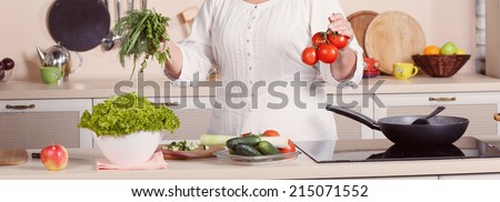Close up of human hands cooking vegetables salad in kitchen. Adult woman, hands only,  working in the kitchen. Woman prepares a salad. Cooking and food concept. Woman while preparing food in kitchen.
