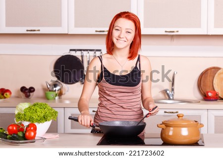Cook food on the stove. Young girl fries and cooks the food in the pan. Cook healthy food. Electric stove for cooking. Woman housewife sweat lunch, breakfast, dinner. Vegetables for eating, cooking.