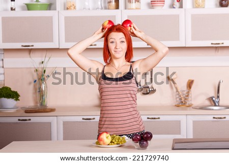 Cheerful girl holding a red apple. Laughter and joy, smile on the face of the woman. Diet, healthy, nutrition, fruits, youth, beauty - concept illustrations for the lifestyle of a modern urban women.