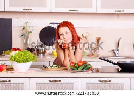 Woman doing vegetable salad of red tomato in the home kitchen. Red tomato in hand. Offer vegetables for diet food. hostess, lunch, breakfast, dinner. Vegetables to eat. Cooking on the kitchen table.