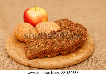 Biscuits baked from flour and bran. Cut pieces of black crusty bread. Diet bread useful for a healthy diet. Different types of bread is piled on the table in the composition. White and brown bread.