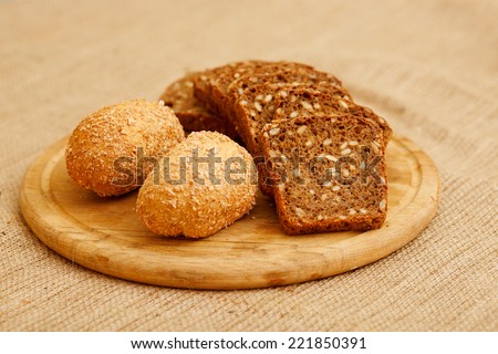 Biscuits baked from flour and bran. Cut pieces of black crusty bread. Diet bread useful for a healthy diet. Different types of bread is piled on the table in the composition. White and brown bread.