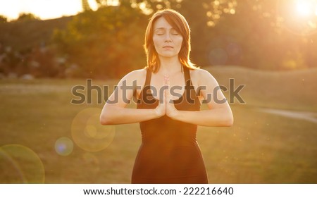 Woman yoga illuminated sun at sunset. Modern young woman in nature in clothing for fitness and yoga classes. Good mood, healthy body, meditation, favorite pastime, happily spending time.