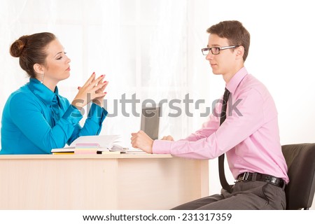 Man and woman - a job interview or business meeting. Male student came to the office to get a job. HR Manager conducts the first interview. Agree on. Discuss the possibilities of business cooperation.