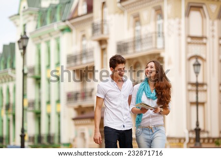 Man and woman traveling by the old city in Europe. Travel, vacation, tourism and friendship - concept group of friends with map in city. Summer holidays, dating, tourism, map - love story in old city.