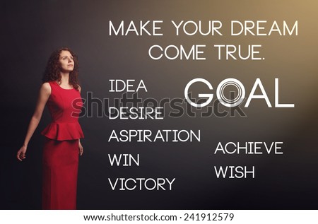 Make your dream come true. Young woman in a red dress on a gray background. Rays of light in the dark. idea, desire, win, wish, victory, goal - concept desire to keep the selected goals and dreams.