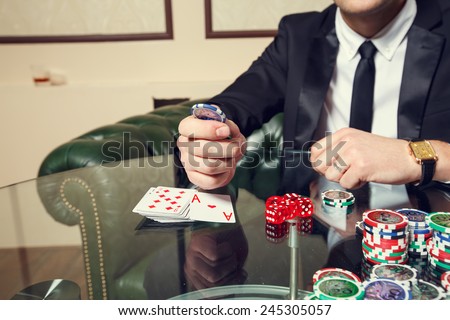 Gambling, male players. On the gaming tables are red dice, cards, casino chips - concept gambling addiction. People tend to take risks and to gambling. Play and win the success of the player.