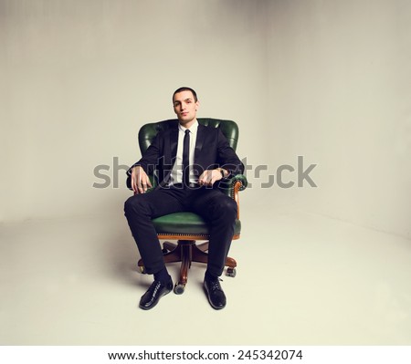 Businessman sitting in the big chair. Manager, Boss. Think about work, business, transactions, money, profit, revenue, graphics deal. To reflect on the issues of work and production. Business attire.