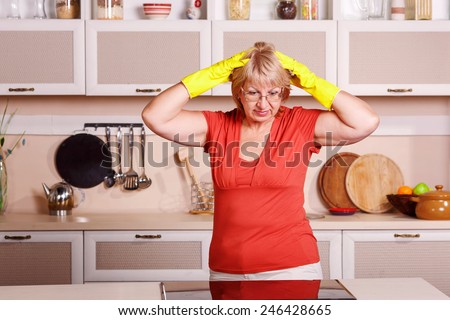 Adult woman makes cleaning the kitchen. Woman in yellow gloves cleaning the kitchen. Cleanliness, order, shine, clean, shiny, cleaning after the holidays at home kitchen. attractive middle aged woman.