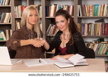 Two women young employee of the office and the student on probation. Women work together. Female business. To agree to come to terms with each other. Make the right decision. Practice in the office.