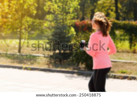 Woman blur, sport, outdoor (motion blurred image). Silhouette with motion blur of a woman athlete running at sunset or sunrise. fitness training of marathon runner. woman on jog along the park.
