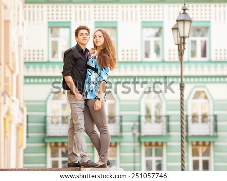 A pair of lovers people on the city walk. The love story of two young people. Man and woman embracing each other. Walking through the city summer day. Feelings of love between two people. Love story.