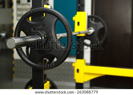Gym. Gymnasium with sports equipment. Barbells, dumbbells - equipment to work on muscle mass. Fitness club weight training equipment gym. Barbell ready to workout, indoors, shallow