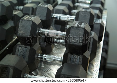 Gym. Gymnasium with sports equipment. Dumbbells, barbells, dumbbells - equipment to work on muscle mass. Morning exercises for vitality afternoon. In modern sports club. Weight training equipment.