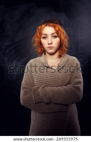 Sad young girl. Woman no smiles. Close up portrait of an attractive young woman laughing with hair blowing. The woman is not smiling. Young red-haired girl with very serious expression on his face.