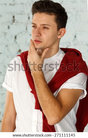 Thoughtful handsome male. Portrait of handsome young thoughtful man over wall brick background.