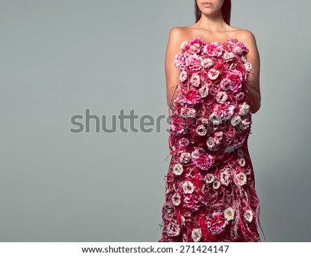 Woman in dress of red and pink flowers. Woman not face, just the body covered with flowers. Woman body flowers, gray background. Bouquet of flowers in the form of the female body. Concept art flower.