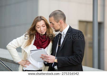 Business man and woman on background blurred building office center, during a business meeting. Business hours. Students intern. Business people - man and woman. Successful group of business people.