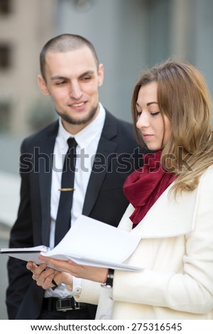 Business man and woman on background blurred building office center, during a business meeting. Business hours. Students intern. Business people - man and woman. Successful group of business people.
