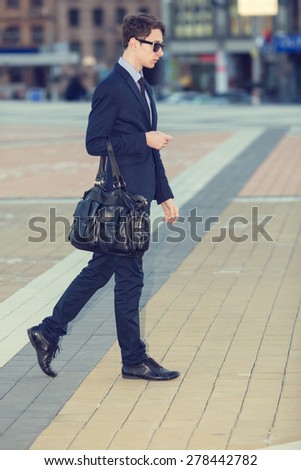 Business man walking in the city. Business people at rush hour walking in the street. confident business man carries his suit jacket over his shoulder while walking down the sidewalk in the city.