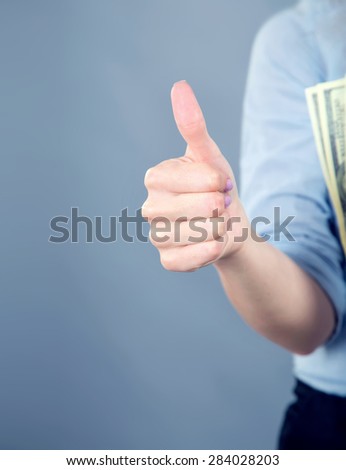 Thumb up. Women\'s hand shows the sign that everything is fine, everything is very good. Woman thumb up on blue background. Space for text. Left, right. Concept about the good things and the good news.