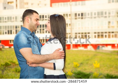 Love Story. Young man and woman together. Multiethnic couple in love. Walk a summer day in the city or in the park where the many green plants. They trips after the wedding. Joint experience emotions