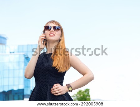 Business woman talking on mobile phone. Young modern beautiful woman. Stylish business woman. Woman on the background of the city street. Get out of the office. Girl student. Smart phone conversation