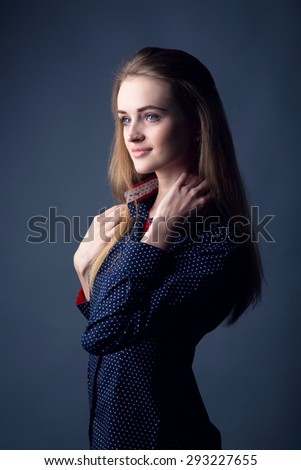 Modern stylish young woman model standing on a dark background. Ordinary people can be a photo model. Portrait of a modern woman. Woman happy. Or a girl student. Beautiful business woman.