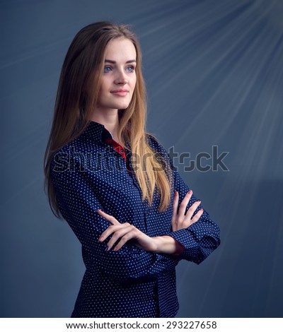 Stylish young woman model standing on a dark background. Ordinary people.  Photo model. Portrait of a modern woman. Woman lit by the rays of light. Concept for information on religious or health.