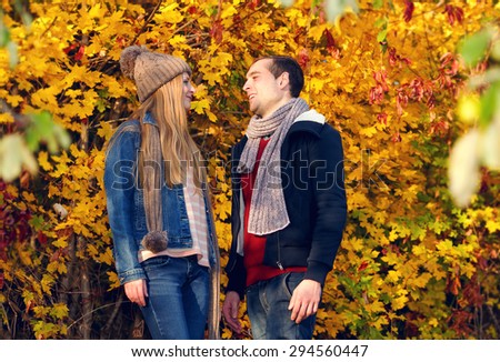 Happy couple in autumn garden. Happiness man and woman talking to each other. Girl offers apple guy together outdoors. Eat apples - healthy food. Love story of one autumn afternoon in the city park.