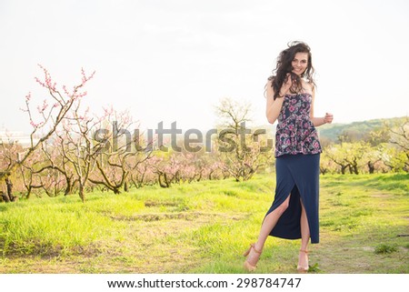 Happy young woman at summer sun day. Fashion woman. Young brunette woman on the background of blooming sunny nature park. Natural beauty. Summer day. Fashion woman in nature.