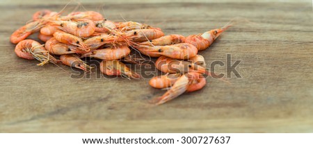 Shrimps. Sea products. Shrimp from the Black Sea. Snack to beer and wine. Serve cooked shrimp on a wooden plank. Delicious fresh cooked shrimp prepared to eat. Cooked shrimps on wooden table.