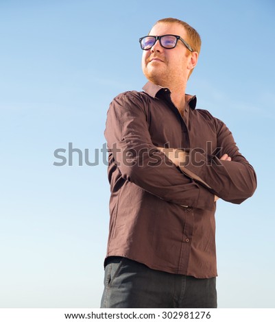 Portrait of a modern business person. Serious man. Confident mature man smiling. Outdoor portrait of handsome man posing at blue sky. Life style. Charismatic man glasses.