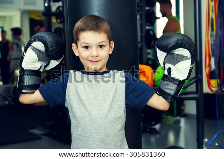 Boy boxer. Sport. Boy champion - boxing, fitness,  Young boy standing by bag boxing. Boy has been in the gym for boxing. Young man in a sports hall near the bag for boxing. Prepare for competitions.