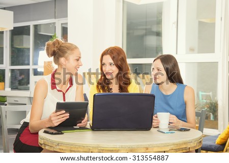 Three woman - students, young women office workers. Meeting, to discuss joint issues. Teamwork on the project. Multinational team of female indoors office or conference room for training. Toned image
