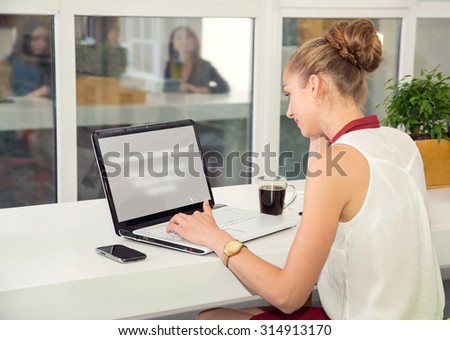 Woman with laptop. Young woman working at a laptop in the office. Business woman - office worker. Girl student to work at a computer. Search for information on the Internet. Woman searching on laptop.
