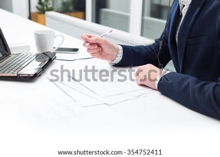 Closeup male hand, table and document. Businessman working on computer with documents. Business man using laptop on table in with a cup of coffee. Ordinary working weekdays. Working in the office.