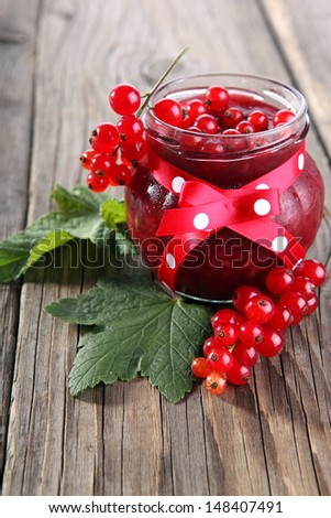 red currant jam with fresh berry on wood background
