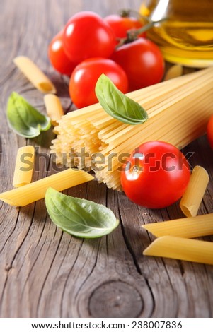 Spaghetti and tomatoes with herbs on an old and vintage wooden table Spaghetti