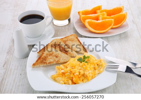 breakfast with scrambled eggs, toasts, juice