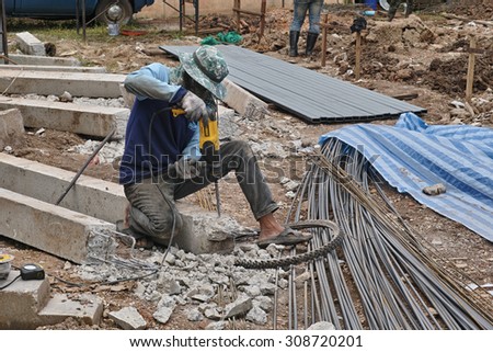 NONG KHAI, THAILAND - August 21, 2015: Worker drill the cement pole at building site in Nong Khai, Thailand