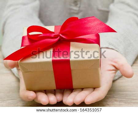gift box tied with a red ribbon in the hands
